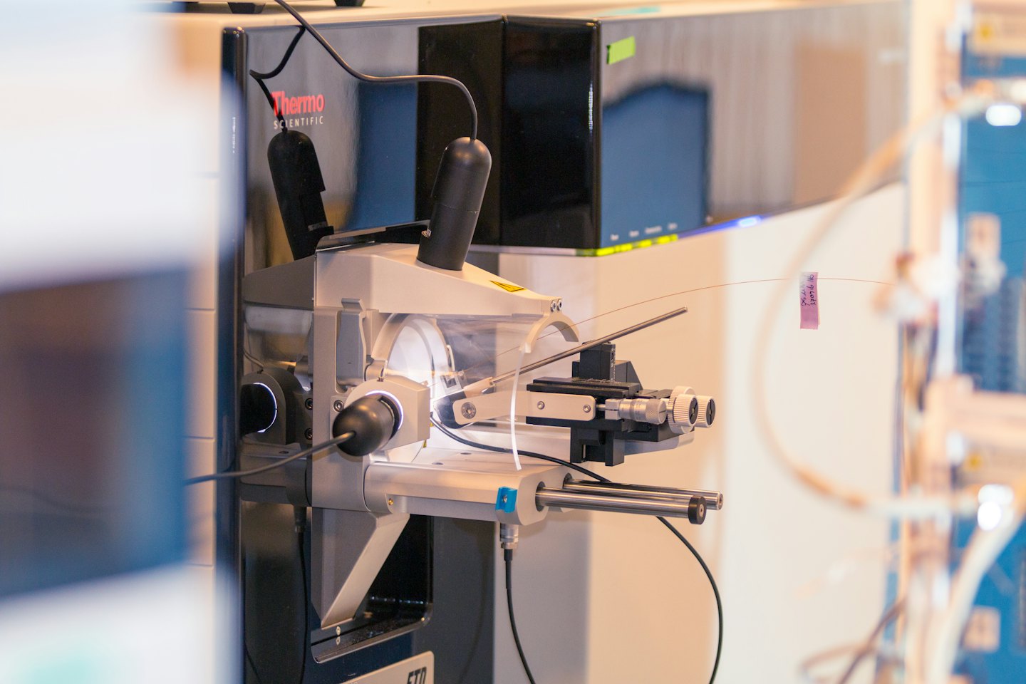 Close-up of complex scientific laboratory equipment with wires and sample holder.