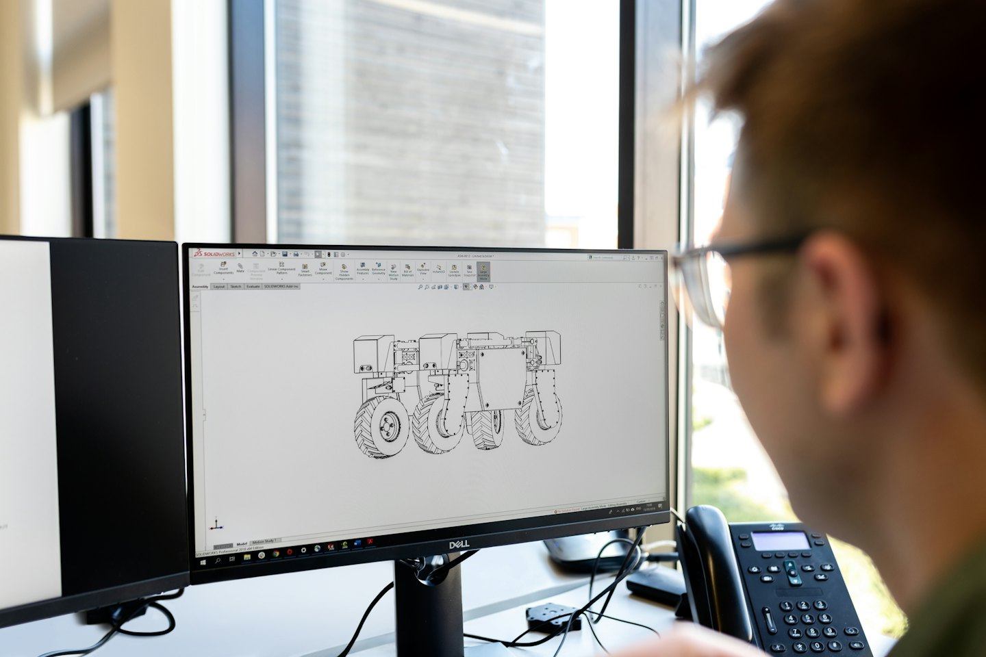 Man designing a robot chassis on a computer.