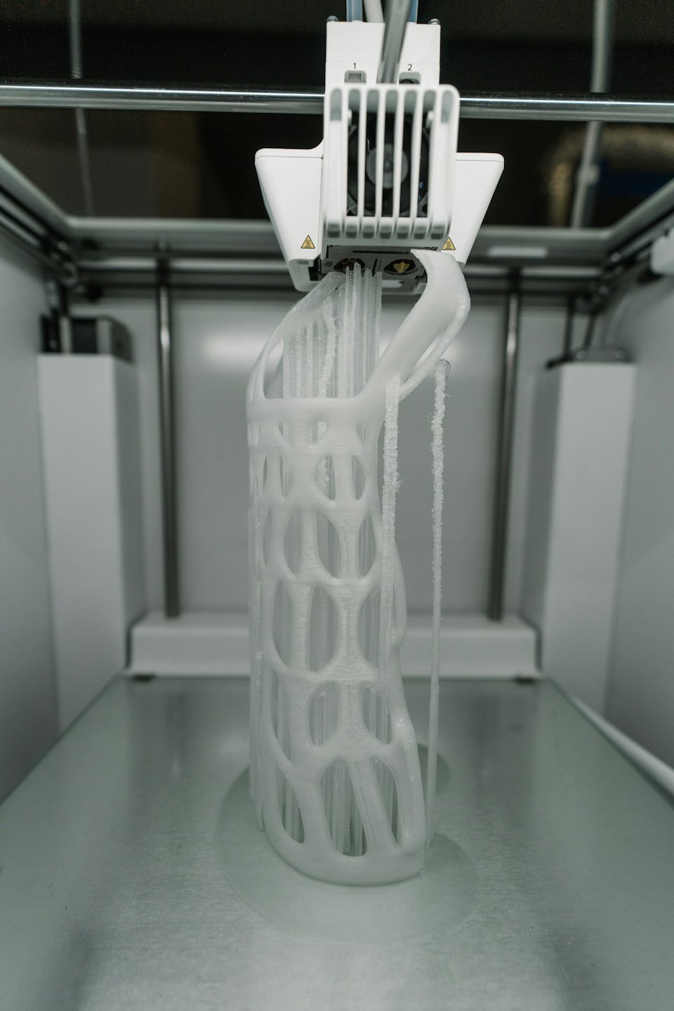 3D printer creating a detailed white lattice object.